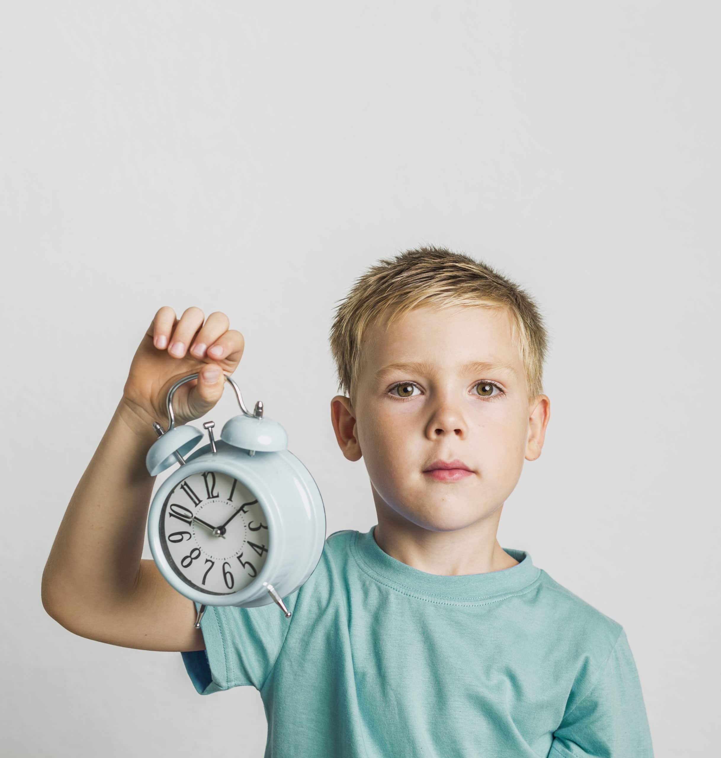 front view cute kid holding clock scaled