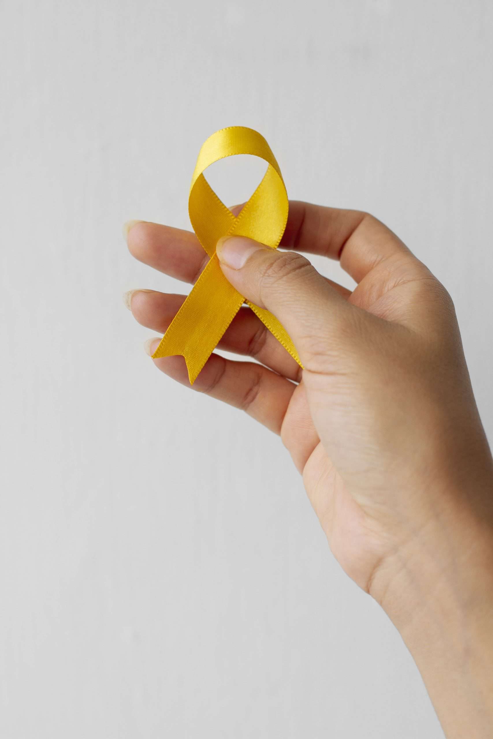 still life yellow ribbon hand min scaled